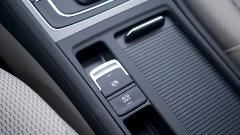 Tlačítka funkce Auto Hold v interiéru automobilu.