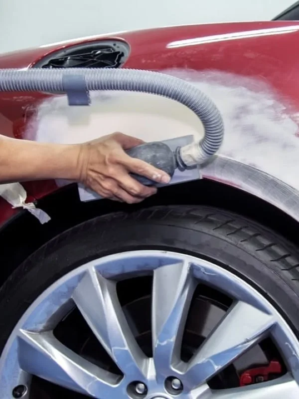 Práce na karoserii: šlapaní poškozeného dílu automobilu.