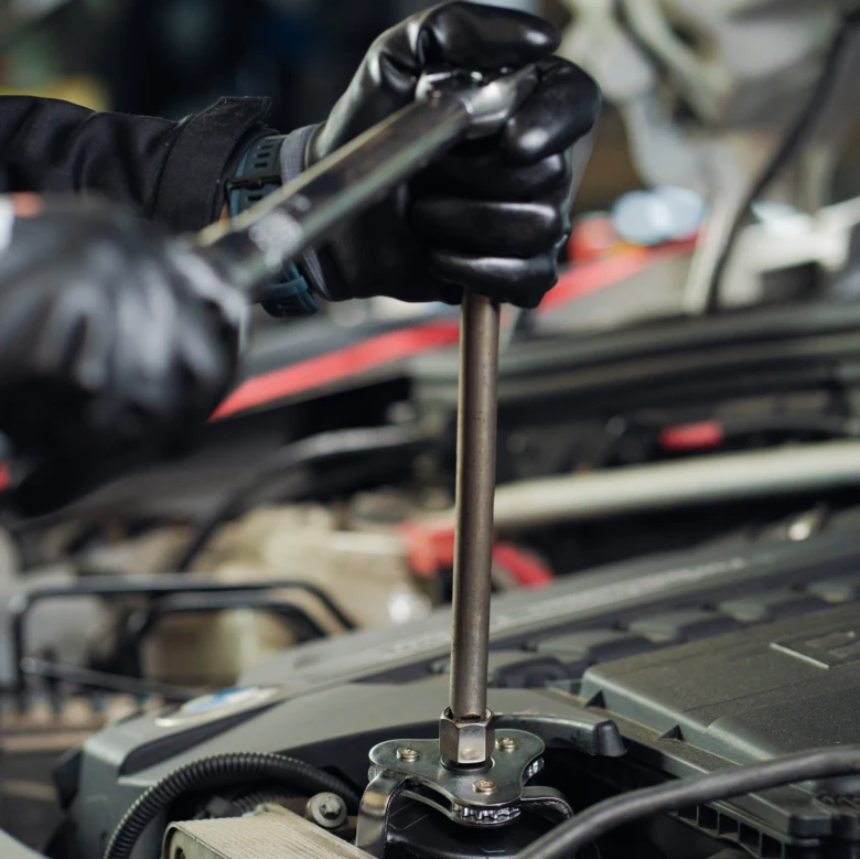 Mechanik opravuje auto klepání v motoru pomocí klíče