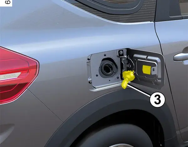Otevřená palivová nádrž u kola automobilu s žlutým uzávěrem.