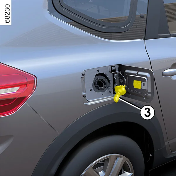 Otevřená palivová nádrž u kola automobilu s žlutým uzávěrem.