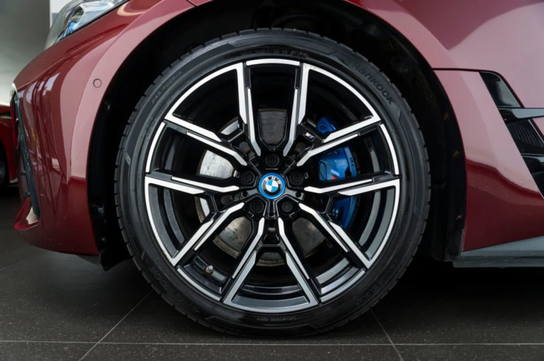 Detail červeného BMW s modrým brzdovým kaliperem.