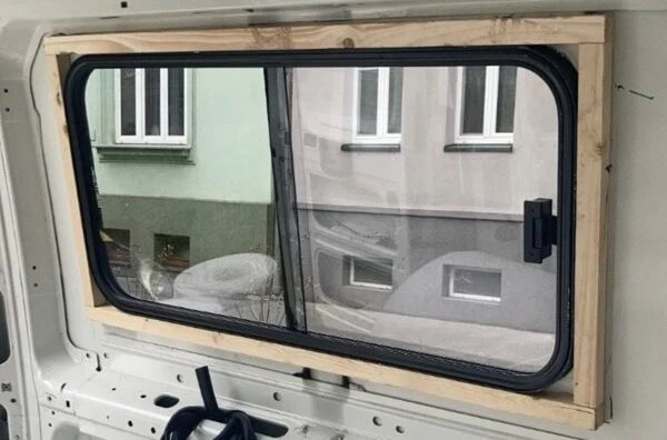 Nainstalované střešní okno do auta s dřevěným rámem.