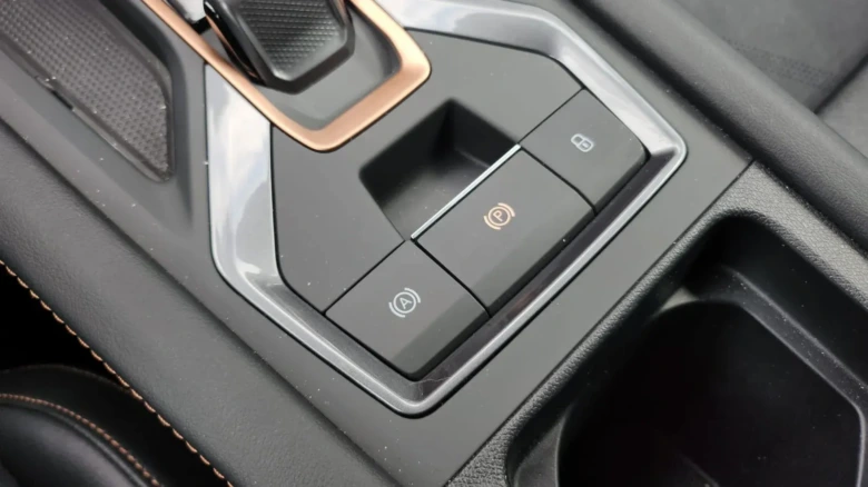 Tlačítka pro elektronický parkovací brzdu a asistent do kopce v autě.