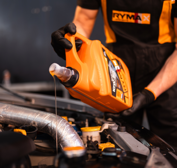 Mechanik nalévá motorový olej do automobilu
