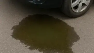 Únik chladicí kapaliny pod automobil na asfaltové ploše.
