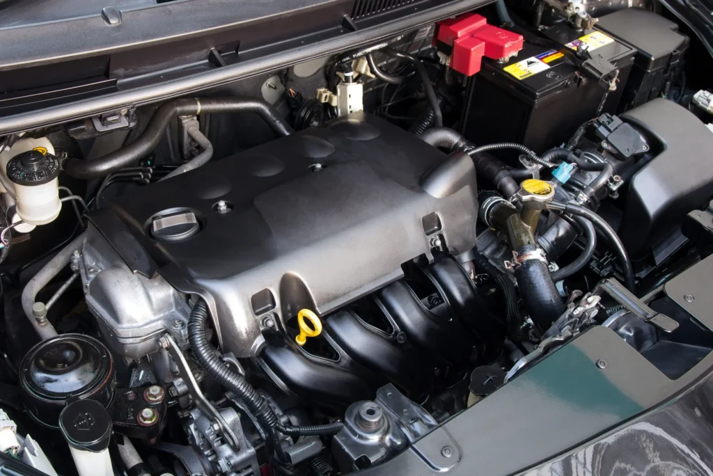 Motorový prostor automobilu s viditelnými komponentami pod kapotou.