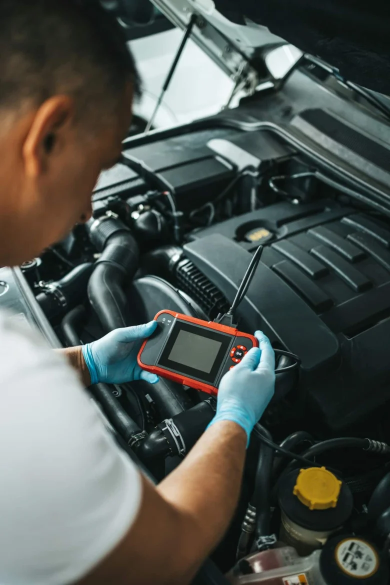 Mechanik používá diagnostický skener pro odstranění chyby motoru.