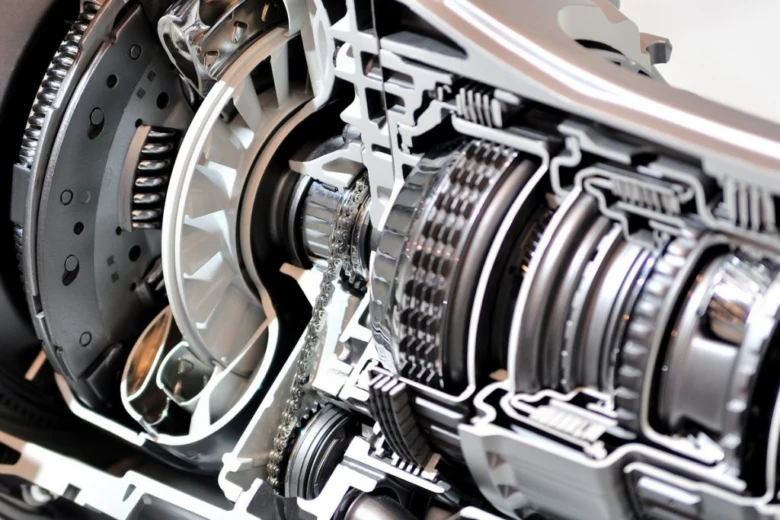 Průřez automobilovou spojkou a převodovkou s viditelnými součástmi.