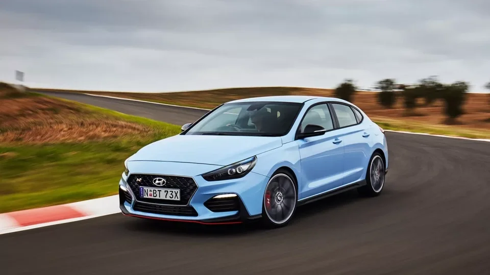 Modrý sportovní vůz Hyundai i30 jezdí po závodní dráze.