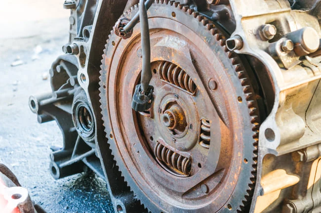 Detailní pohled na spojku s hřídelovým kolem v automobilovém motoru.