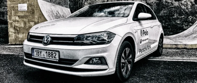 Bílý automobil VW Polo s logem na karoserii.