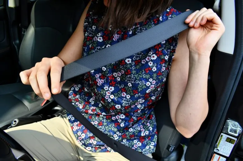 Žena zapíná bezpečnostní pás v autě