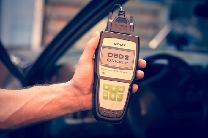 Ruka drží diagnostický skener pro automobil s konektorem ELM327.