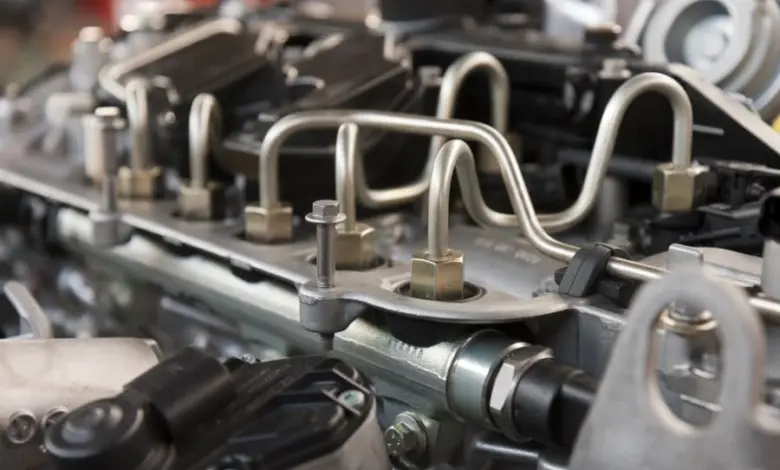 Blízký pohled na motor automobilu s viditelnými svíčkami a kabely.