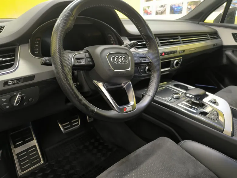 Interiér vozu s černým volantem značky Audi.