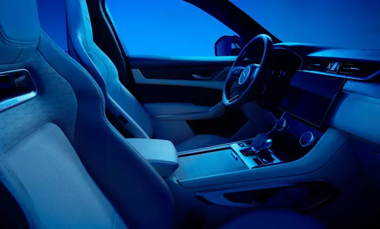 Vnitřek vozu Jaguar F-Pace s modrým osvětlením.