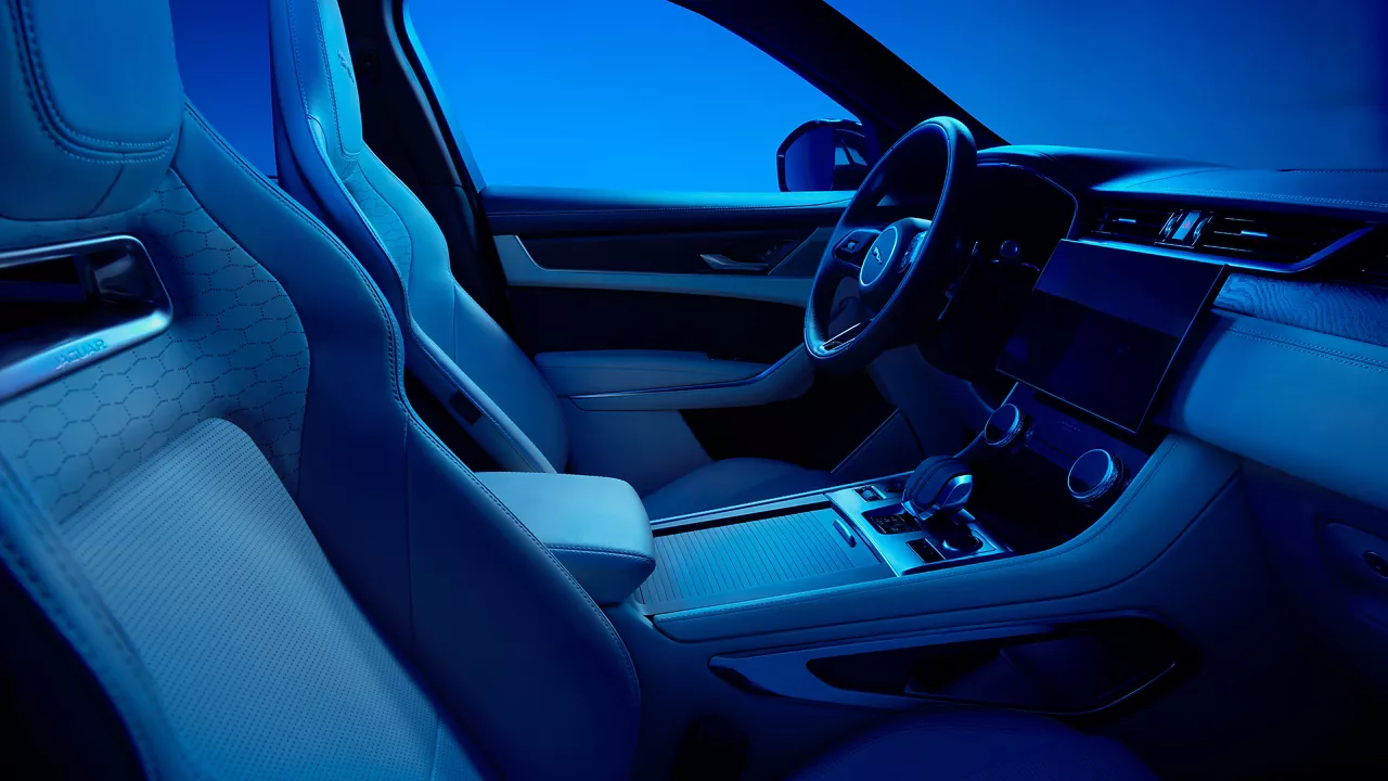 Vnitřek vozu Jaguar F-Pace s modrým osvětlením.