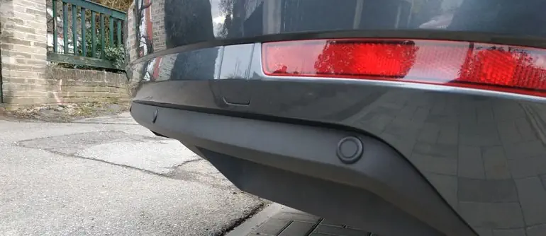 Zadní nárazník auta s parkovacími senzory pro kontrolu funkčnosti.