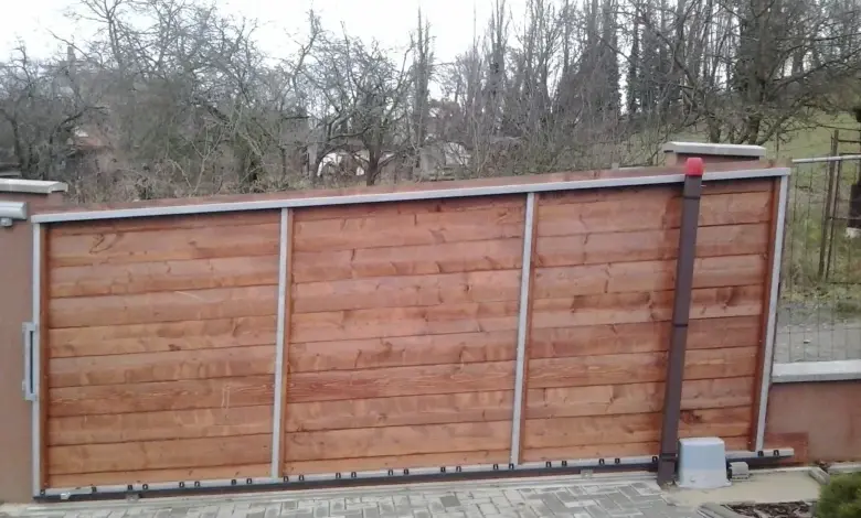 Automatická dřevěná brána se nedokáže zavřít kvůli poruše mechanismu.