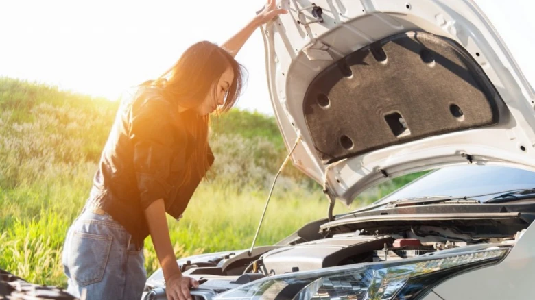 Woman checking car engine