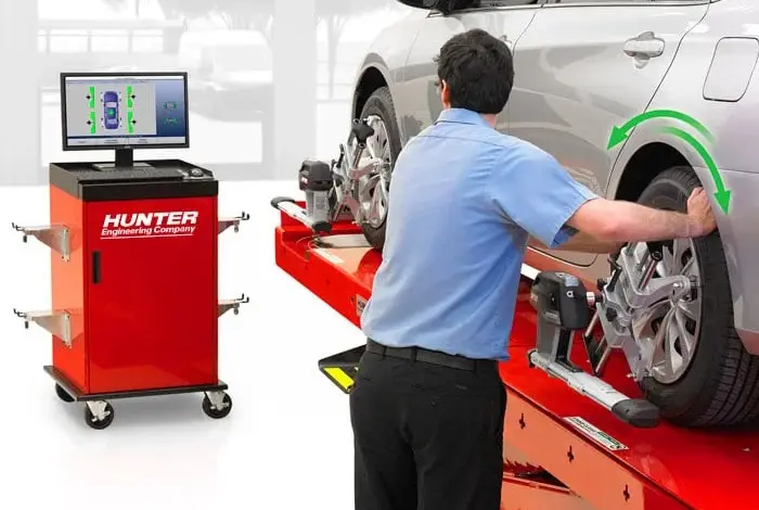 Mechanik upravuje geometrii kol na zvedáku s diagnostickým zařízením.