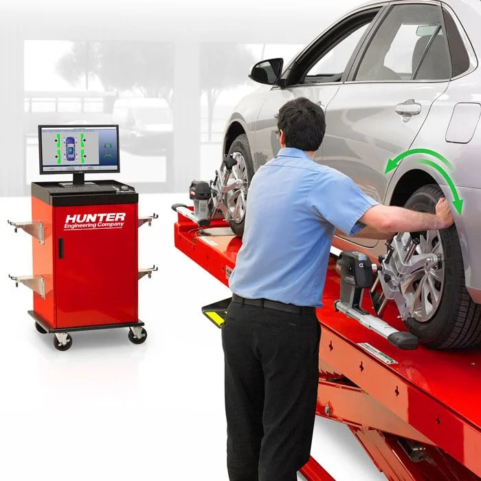 Mechanik upravuje geometrii kol na zvedáku s diagnostickým zařízením.