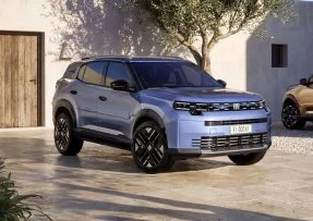Modrá SUV auta zaparkovaná před domem.