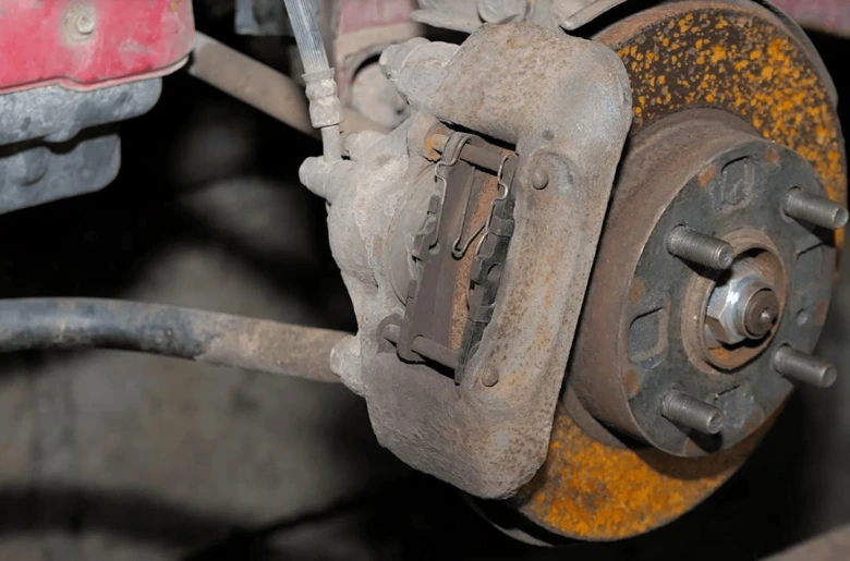 Detailní pohled na brzdový třmen s kotoučem u automobilu.