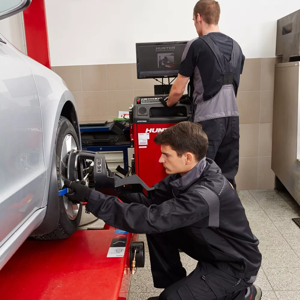 Mechanik nastavuje úhly seřízení kol pomocí specializovaného zařízení.