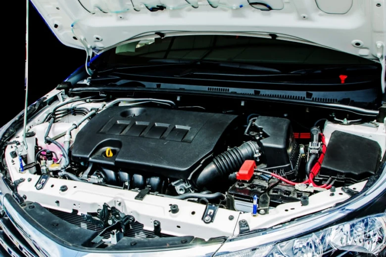 Otevřená motorka automobilu s viditelnými komponenty pod kapotou.