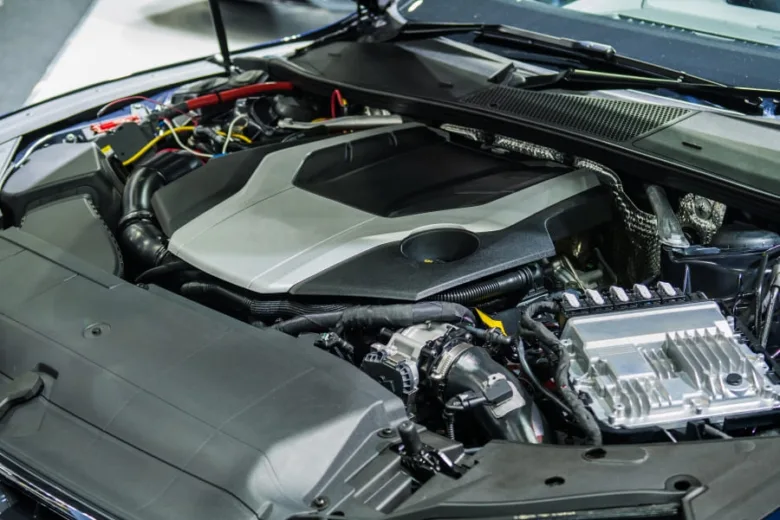 Otevřený motor automobilu s viditelnými součástkami v podkapotí.