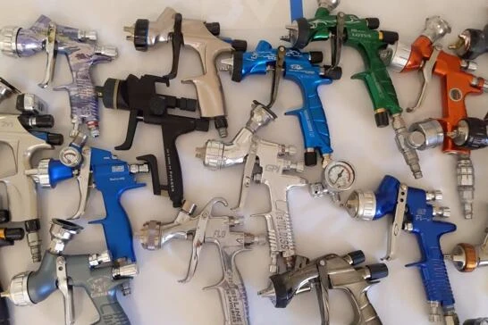 Sada různých sprejových pistolen pro lakování automobilů.
