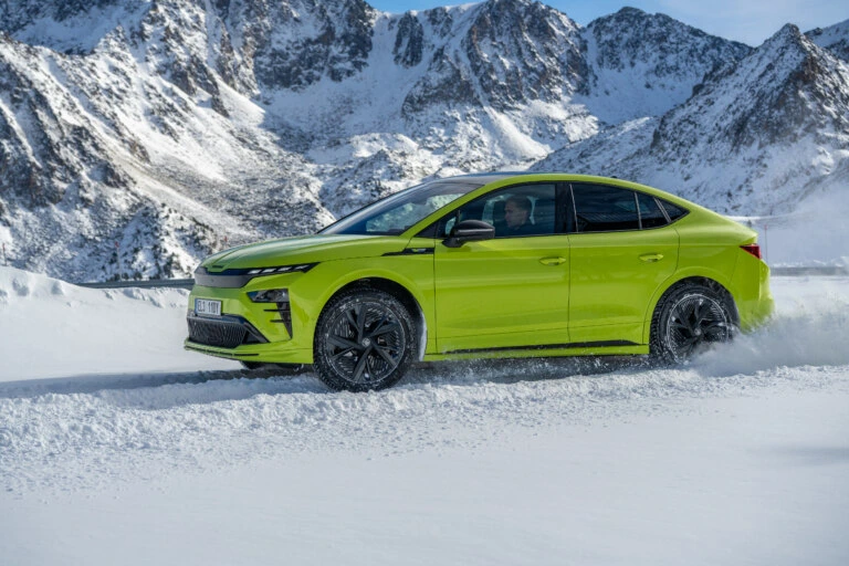 Zelené auto s pohonem všech kol v zimním terénu.