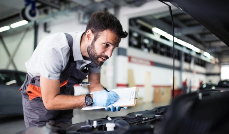Mechanic inspecting car battery